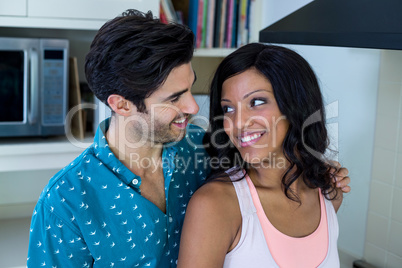 Man embracing woman while cooking in kitchen