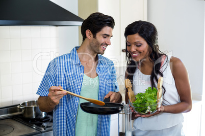 Young couple cooking food together in kitchen