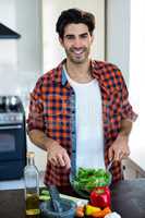 Portrait of man mixing a salad in kitchen