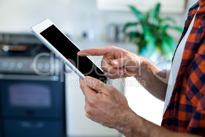 Mid-section of man using digital tablet