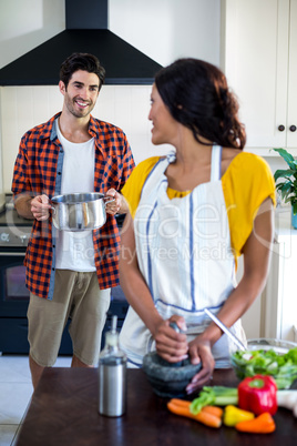 Happy couple talking while preparing food