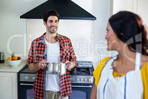 Happy couple talking while preparing food