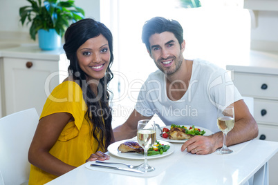 Portrait of happy couple having meal in kitchen