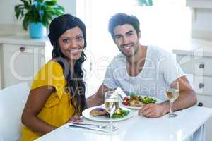 Portrait of happy couple having meal in kitchen