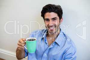 Portrait of happy man holding a cup of coffee
