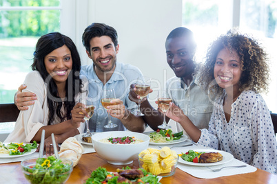 Two couples holding wine glass while having meal