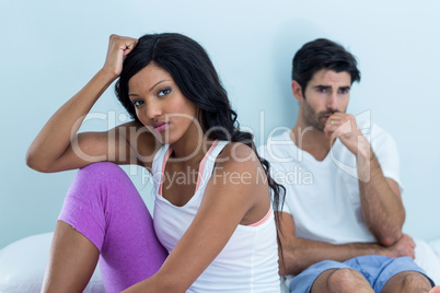 Upset couple ignoring each other after fight on bed