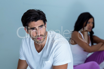 Upset couple ignoring each other after fight on bed