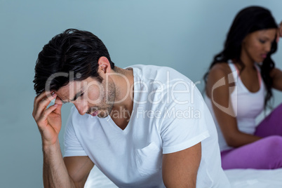 Upset couple ignoring each other after fight on bed