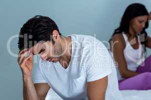 Upset couple ignoring each other after fight on bed