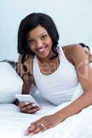 Woman using mobile phone while man sleeping on bed