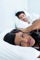 Woman ignoring while man snoring on bed
