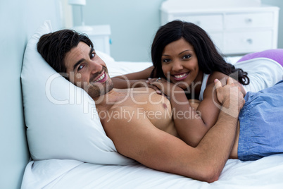 Portrait of romantic couple lying together on bed