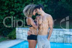 Young couple standing near swimming pool