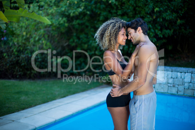 Young couple standing near swimming pool Young couple standing near swimming pool