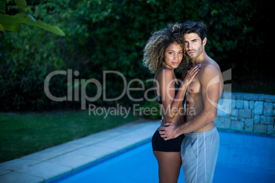 Young couple standing near swimming pool