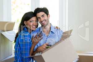 Young couple carrying cardboard box