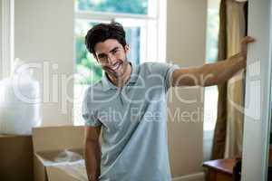 Young man standing in his new house