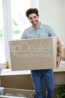 Young man carrying cardboard box