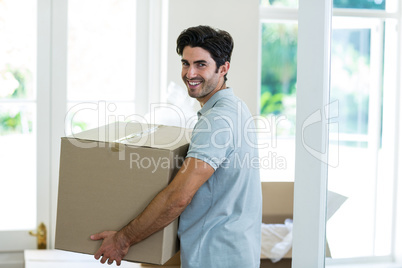 Young man carrying cardboard box