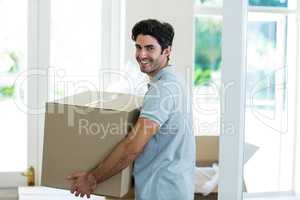 Young man carrying cardboard box