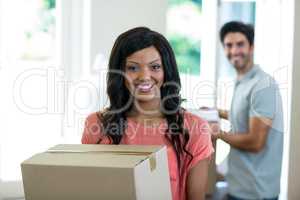 Young couple carrying cardboard box