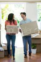 Young couple carrying cardboard box