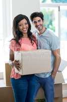 Young couple carrying cardboard box