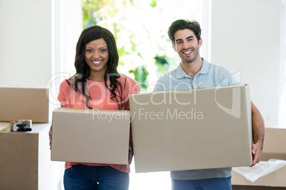 Young couple carrying cardboard box