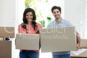 Young couple carrying cardboard box