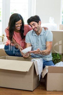 Young couple unpacking carton boxes in their new house