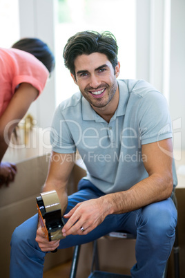 Young man holding a tape sealing machine