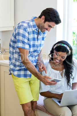 Young couple using mobile phone laptop