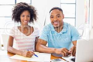 Young couple using laptop while checking bills