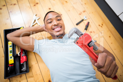 Man showing a wrench while working with a set of tools