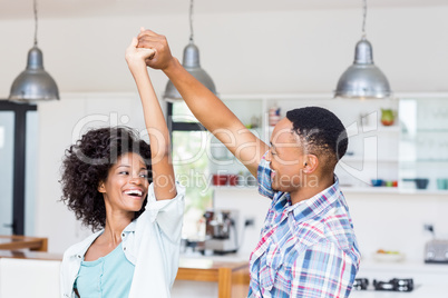 Happy couple dancing in kitchen