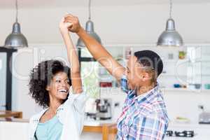 Happy couple dancing in kitchen