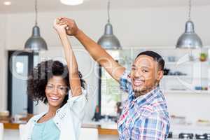 Happy couple dancing in kitchen