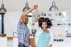 Happy couple dancing in kitchen