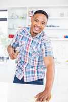 Smiling man cleaning kitchen counter