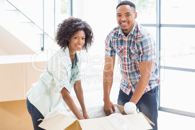 Young couple unpacking carton boxes