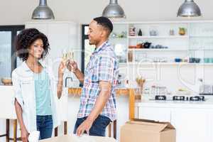 Happy couple toasting champagne glass in kitchen