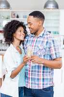 Happy couple toasting champagne glass in kitchen