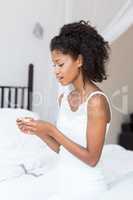 Woman looking at pregnancy test on bed