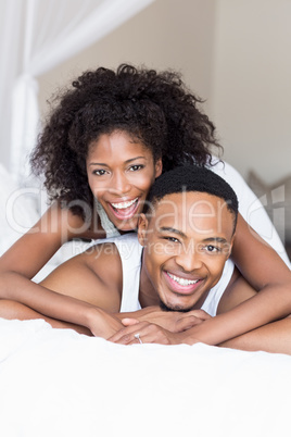 Young couple lying on bed and embracing each other