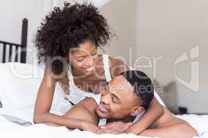 Young couple lying on bed and embracing each other