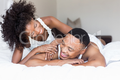 Young couple lying on bed and embracing each other