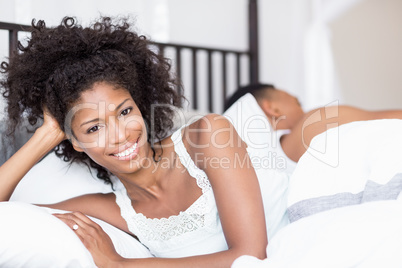 Portrait of happy woman lying on bed