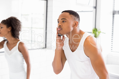 Couple checking their skin in bathroom