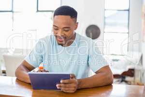 Happy young man using digital tablet